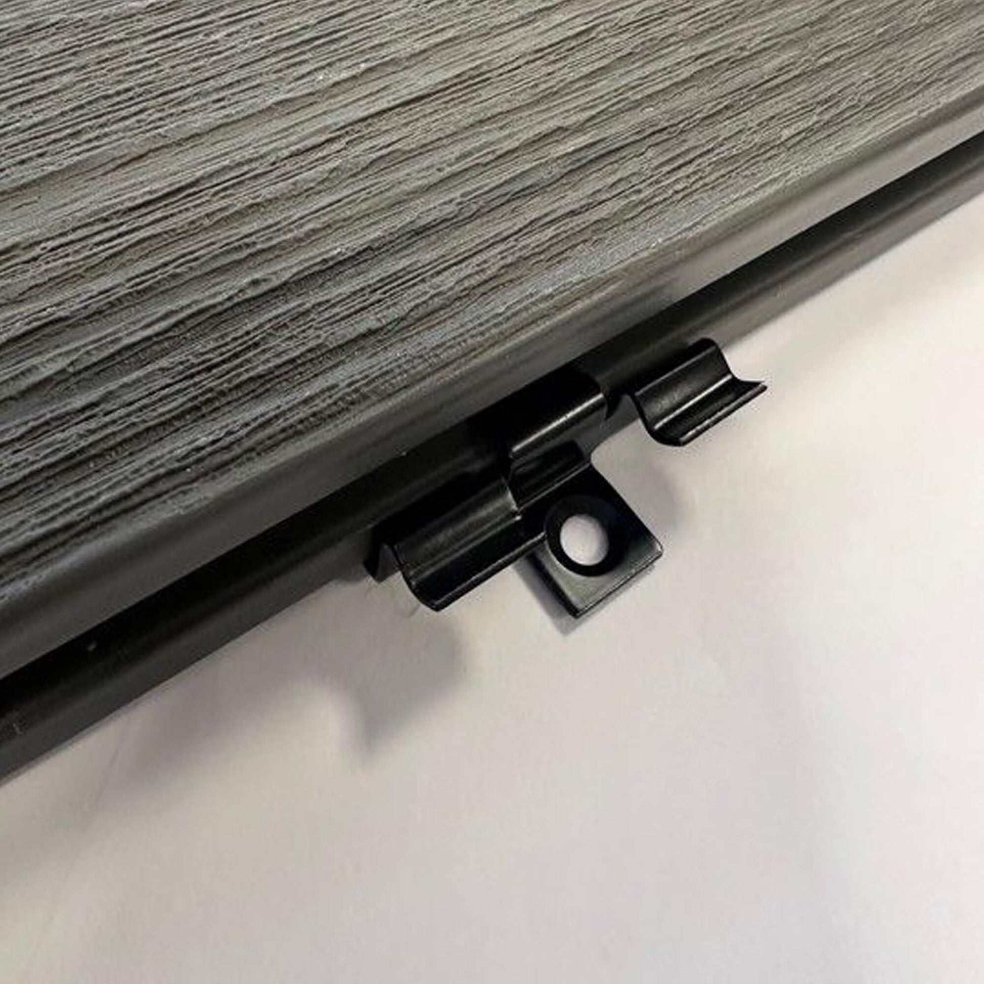 Close-up of a Co-Extruded Decking Hidden Metal Clip on a grey background.