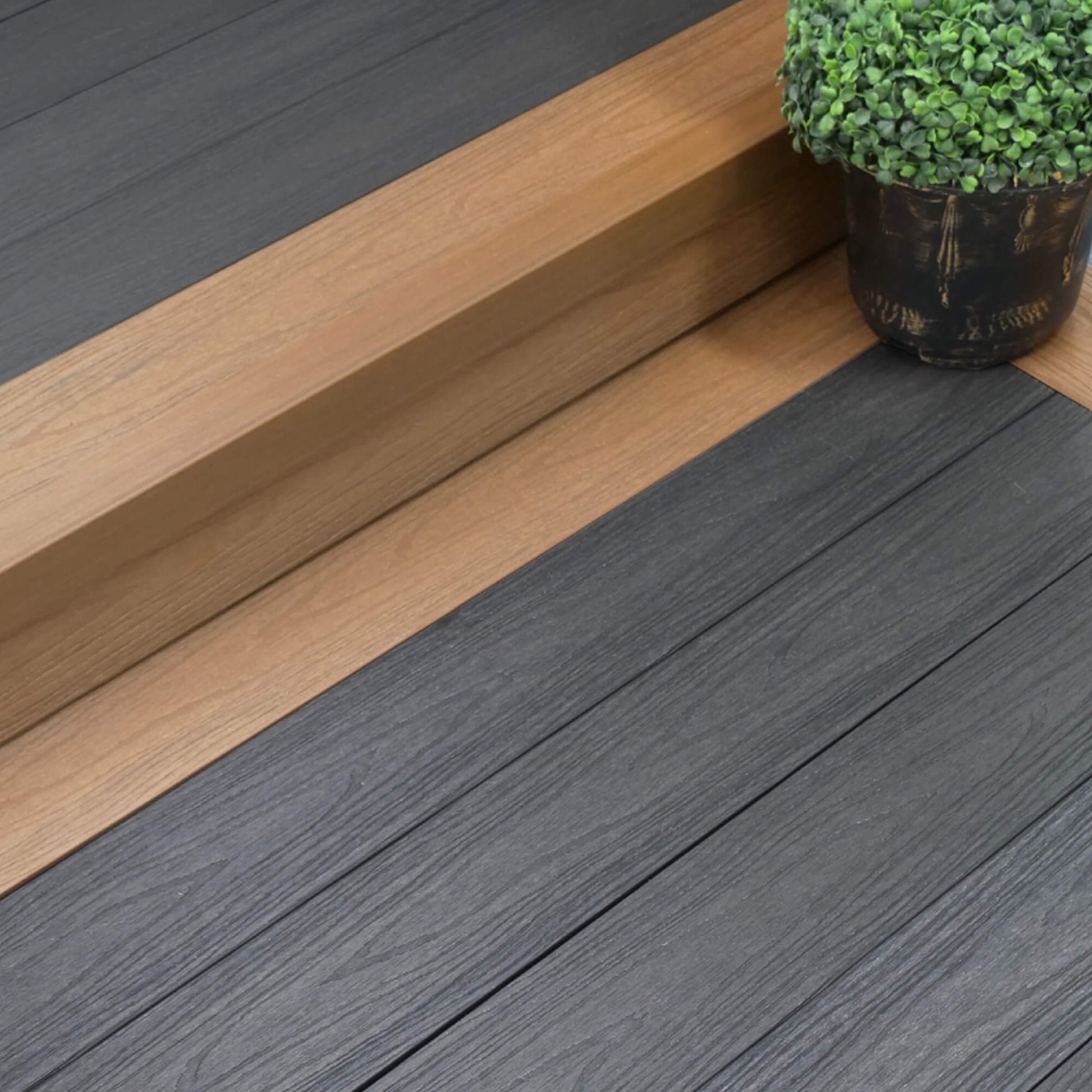 Co-Extruded Teak/Dark Grey Composite Decking in situ in a patio setting.
