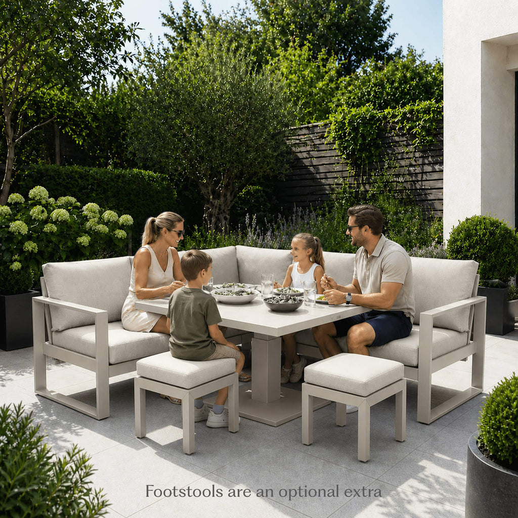 Family sitting outdoors on a Como stone outdoor furniture corner set with additional footstools.