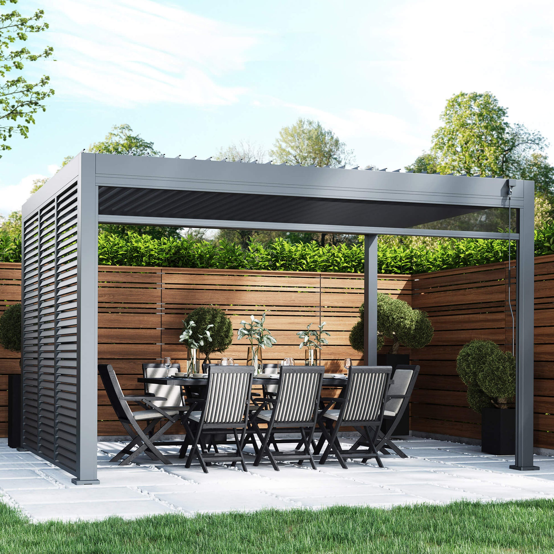 A Riva 4x3m Aluminium Pergola, dining table, and chairs in an outdoor patio setting.